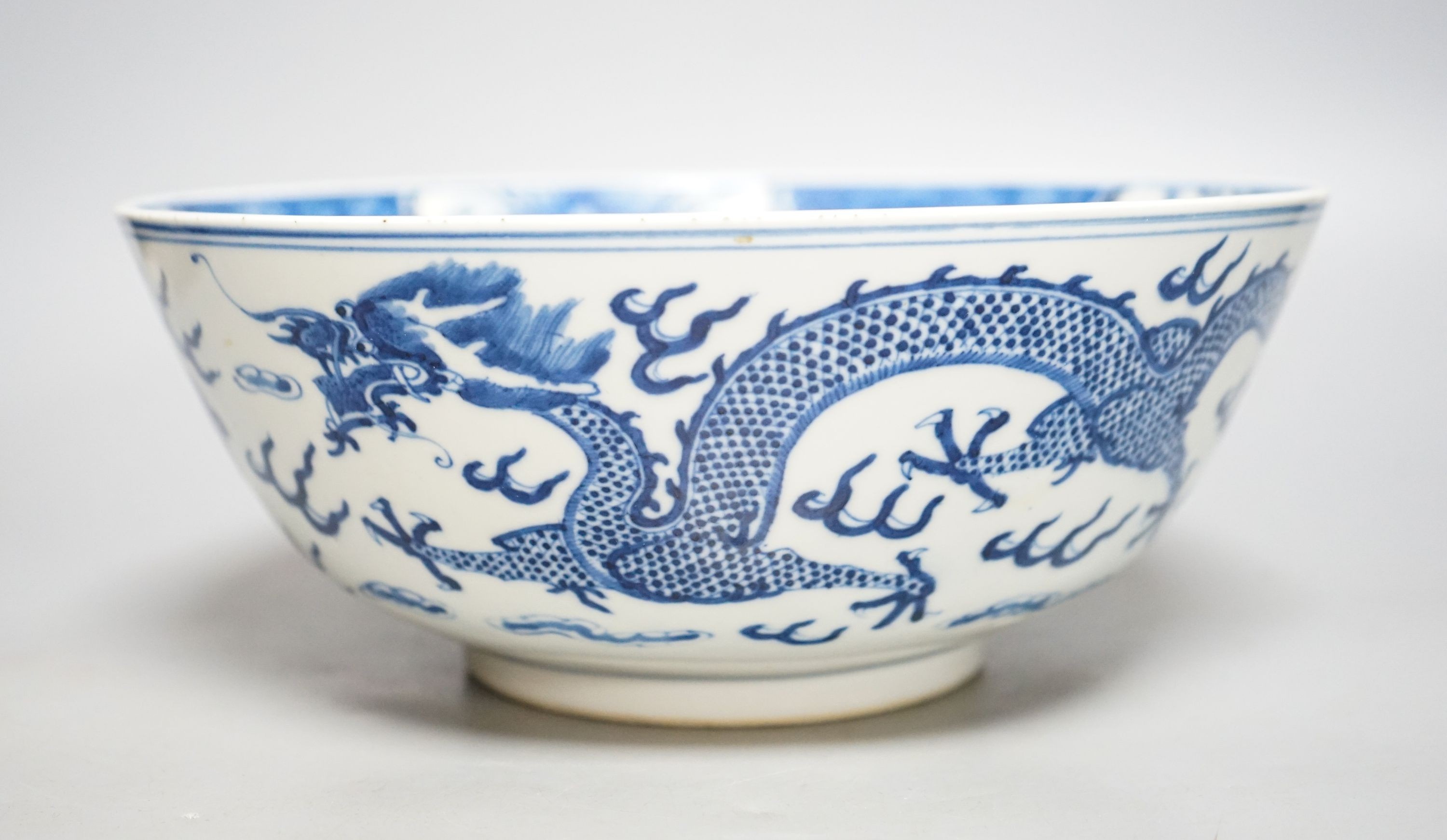 A Chinese blue and white ‘dragon’ bowl, Kangxi mark, late 19th century 25cm